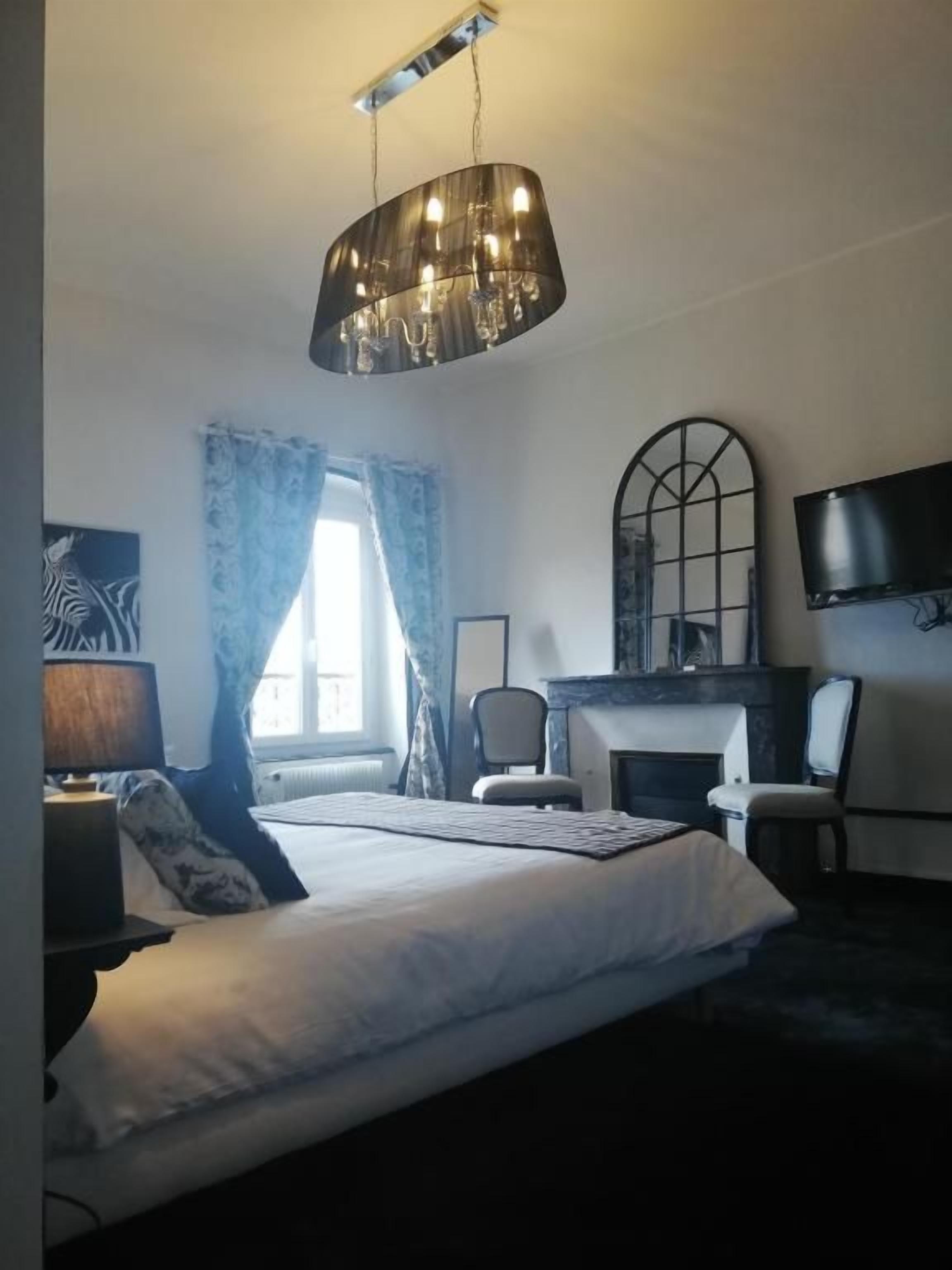 Une chambre d’hôtel équipée d’un lit, d’un bureau, d’une chaise, d’une télévision et d’une cheminée.