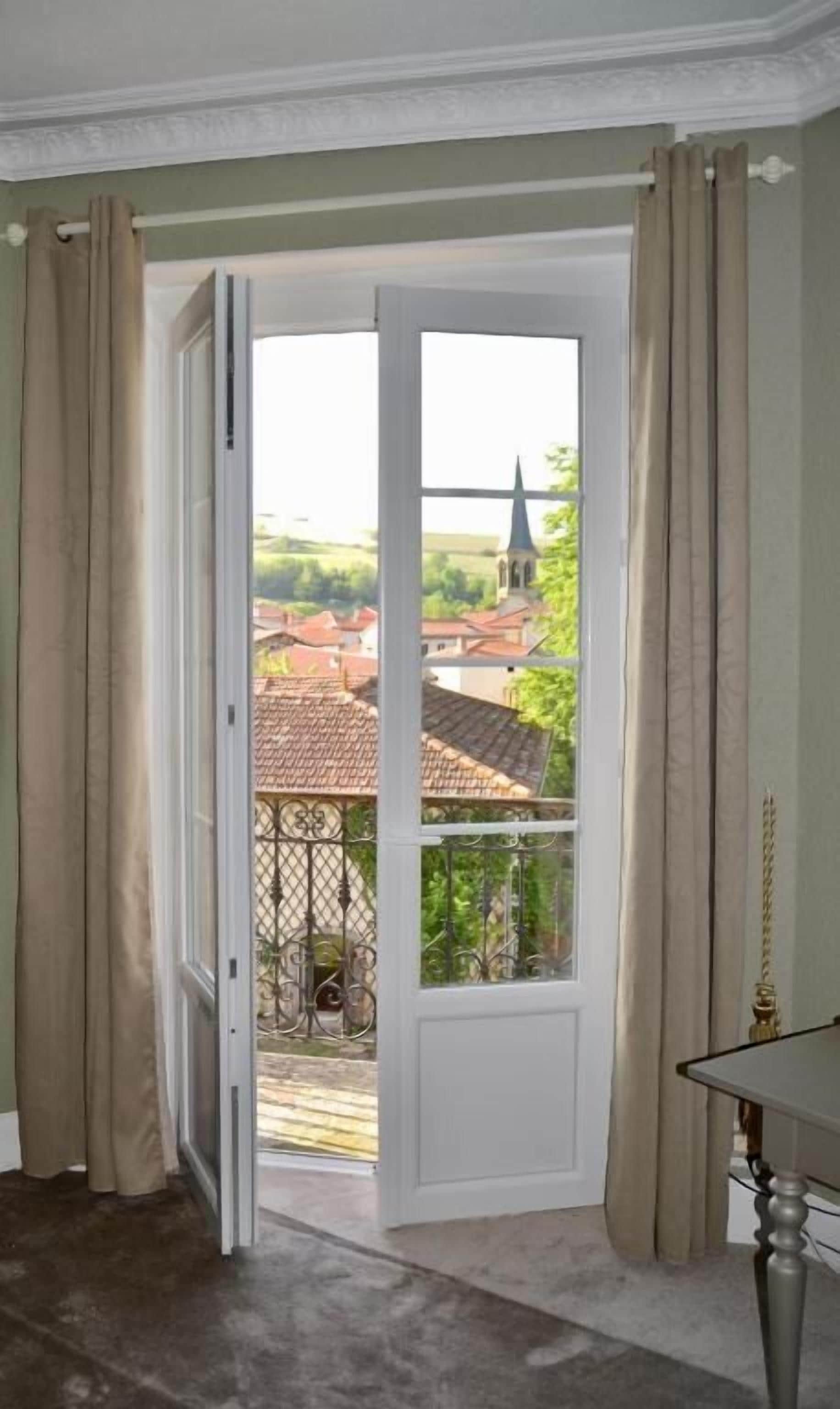 A room with a door leading to an outdoor balcony.