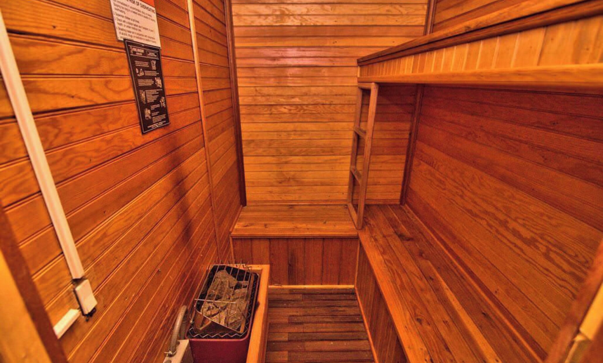 Sauna, jossa on puuseinät ja penkki.