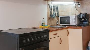 A kitchen with a stove, oven, microwave, and coffee maker.