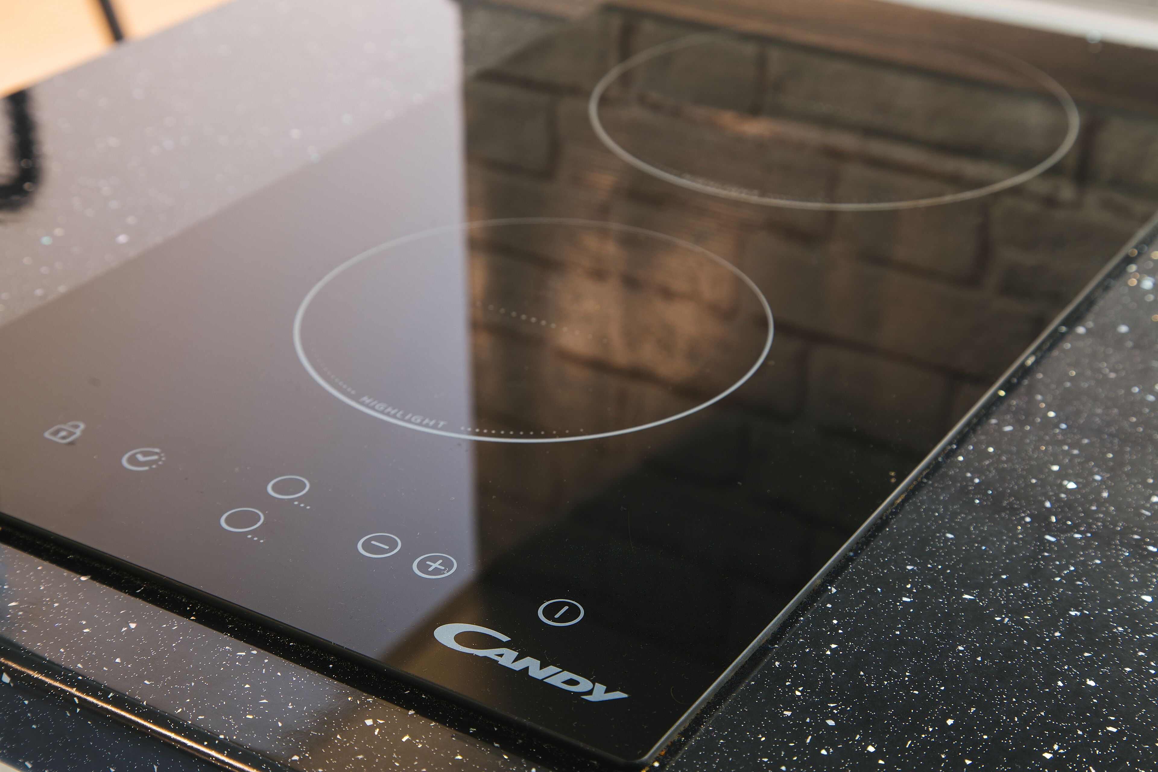 A black induction cooktop with the brand name "Candy" visible on the surface.