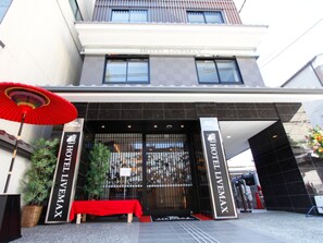 A hotel entrance with a red umbrella, a red table, and a sign reading "HOTEL LITEMAX". - HOTEL LiVEMAX Kyoto Teramachidori (Kyoto)