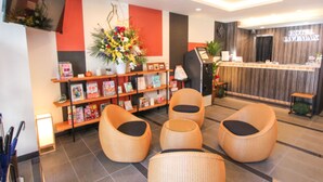 A hotel lobby with wicker chairs, a reception desk, and a large floral arrangement. - HOTEL LiVEMAX Kyoto Teramachidori (Kyoto)