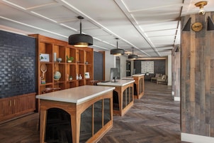 A modern kitchen with wooden cabinetry, pendant lighting, and a herringbone wood floor.