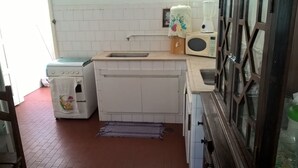 A compact kitchen with white appliances, a sink, and a microwave. - Maria Izabel (Salvador)