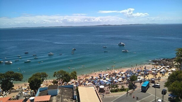 A coastal beach with boats, umbrellas, and people. - Maria Izabel (Salvador)