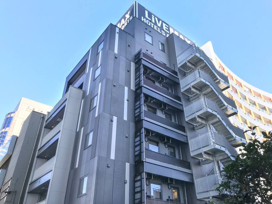 A modern hotel building with multiple balconies and a clear sky.