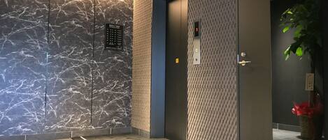 A modern elevator with a marble wall and a patterned wall panel.