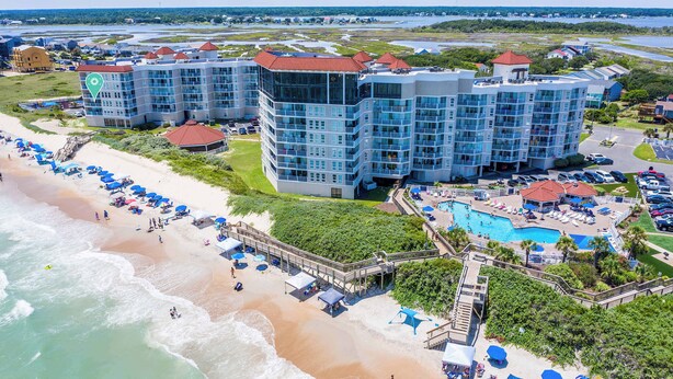 Un resort con varias edificaciones, playa y zona de piscina.