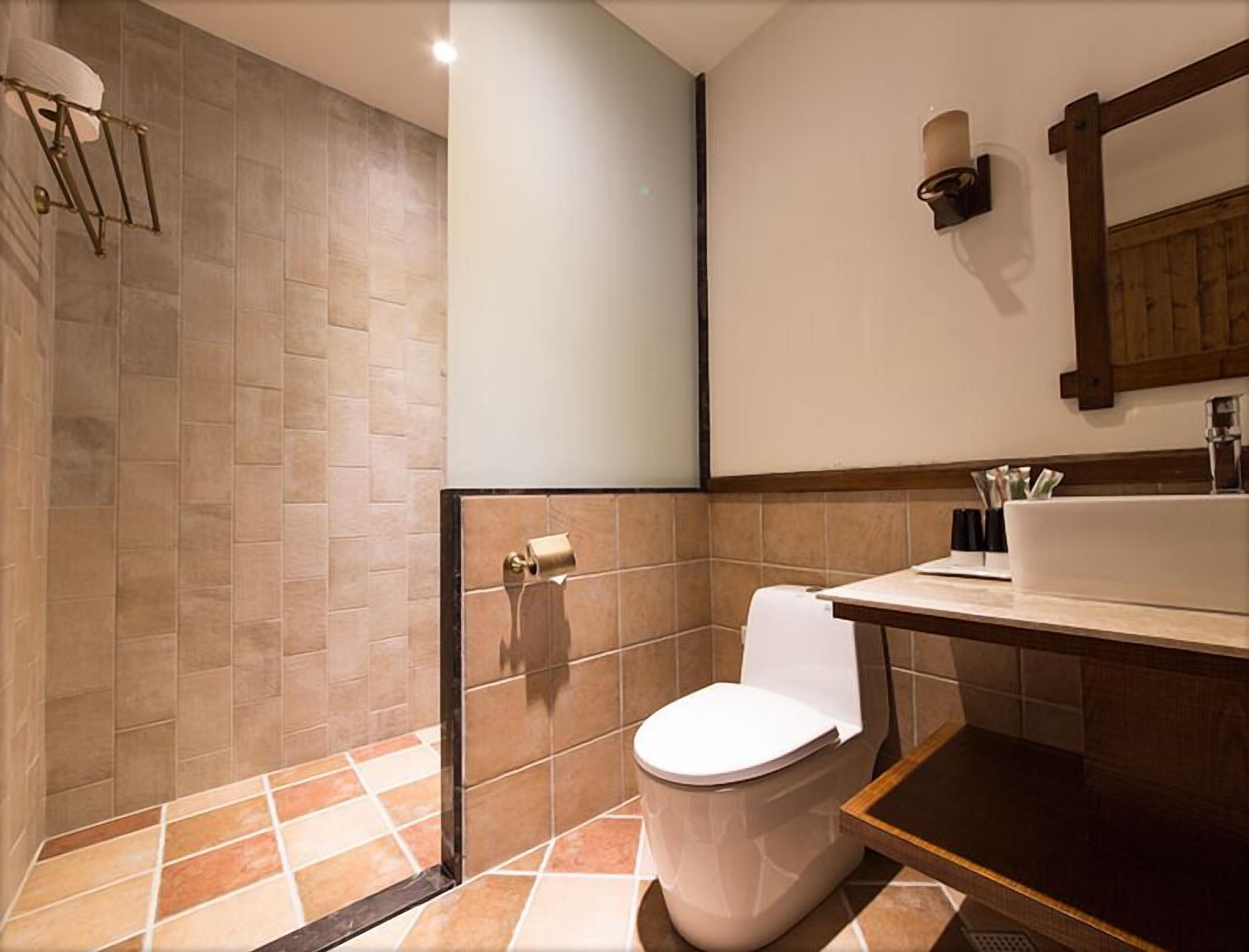 A bathroom with a shower, toilet, and sink.