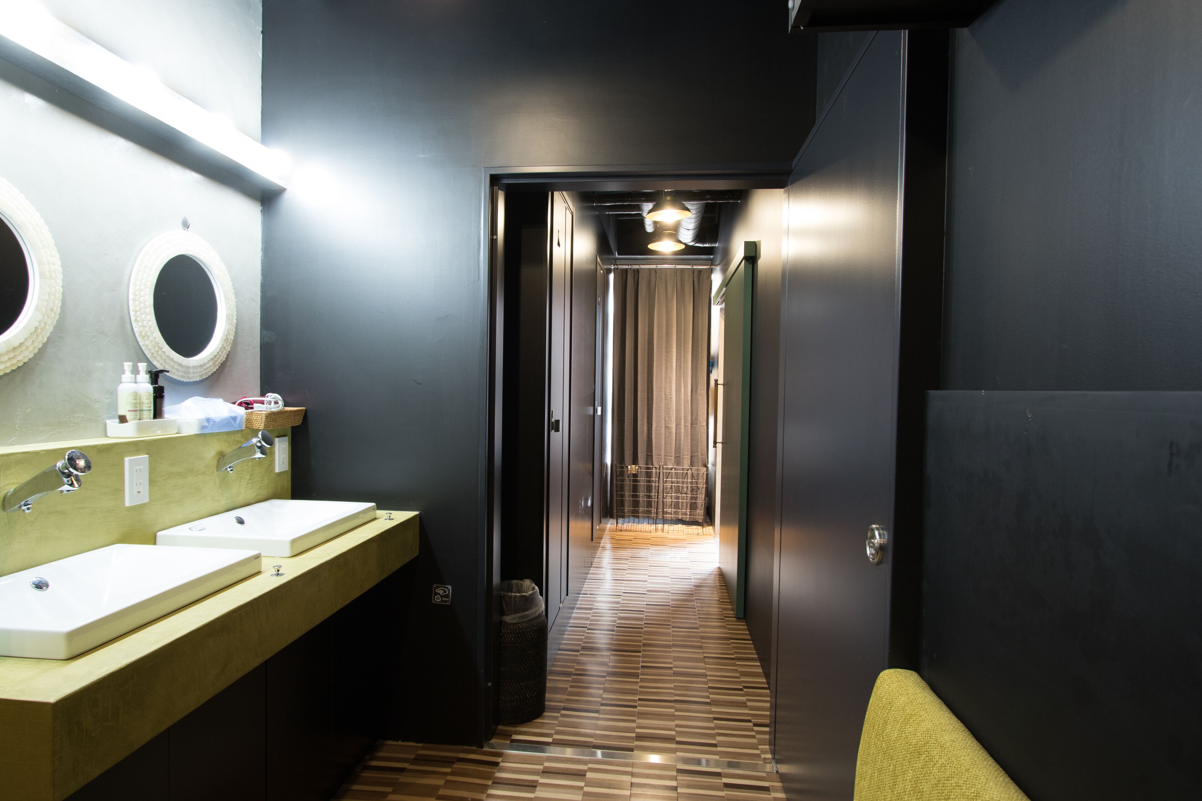 A modern bathroom with two sinks, a mirror, and a towel rack.