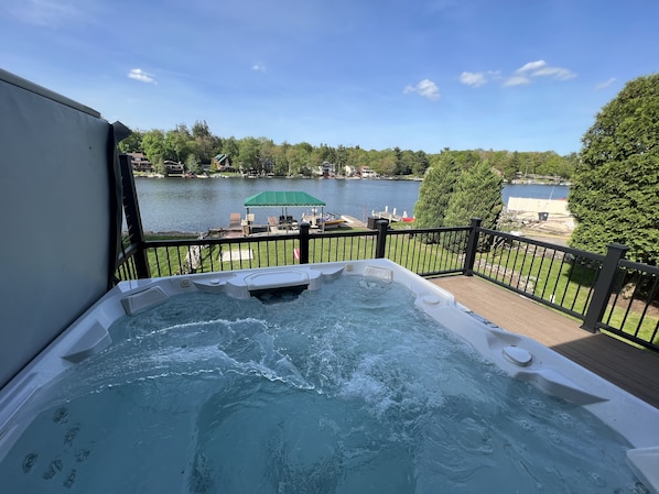 Ein Whirlpool auf einer Terrasse mit Seeblick und umliegender Bepflanzung.