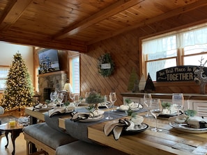 Ein gemütlicher Essbereich mit Holzbalkendecke, einem Weihnachtsbaum und einem Schild mit der Aufschrift 'The Best Place To Be Together'.