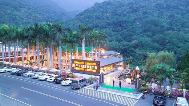 Un hotel con area benessere, circondato da palme e montagne.