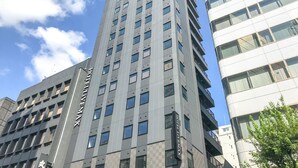 A modern hotel building with a prominent 'HOTEL MAXX' sign, multiple floors, and a clear sky in the background. - HOTEL LiVEMAX Nihonbashi Koamicho (Tokyo)