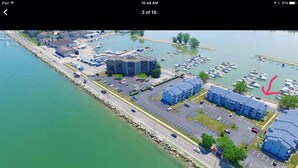 Vista aérea de un puerto deportivo con varios edificios, zonas de estacionamiento y barcos.
