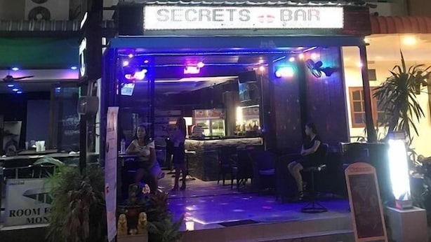A bar named "SECRETS BAR" with a stage and seating area, located in a multi-story building with balconies. - Secrets Pattaya (Pattaya)