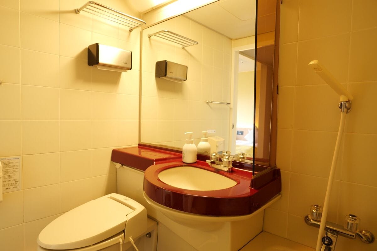 A bathroom with a toilet, sink, and shower.
