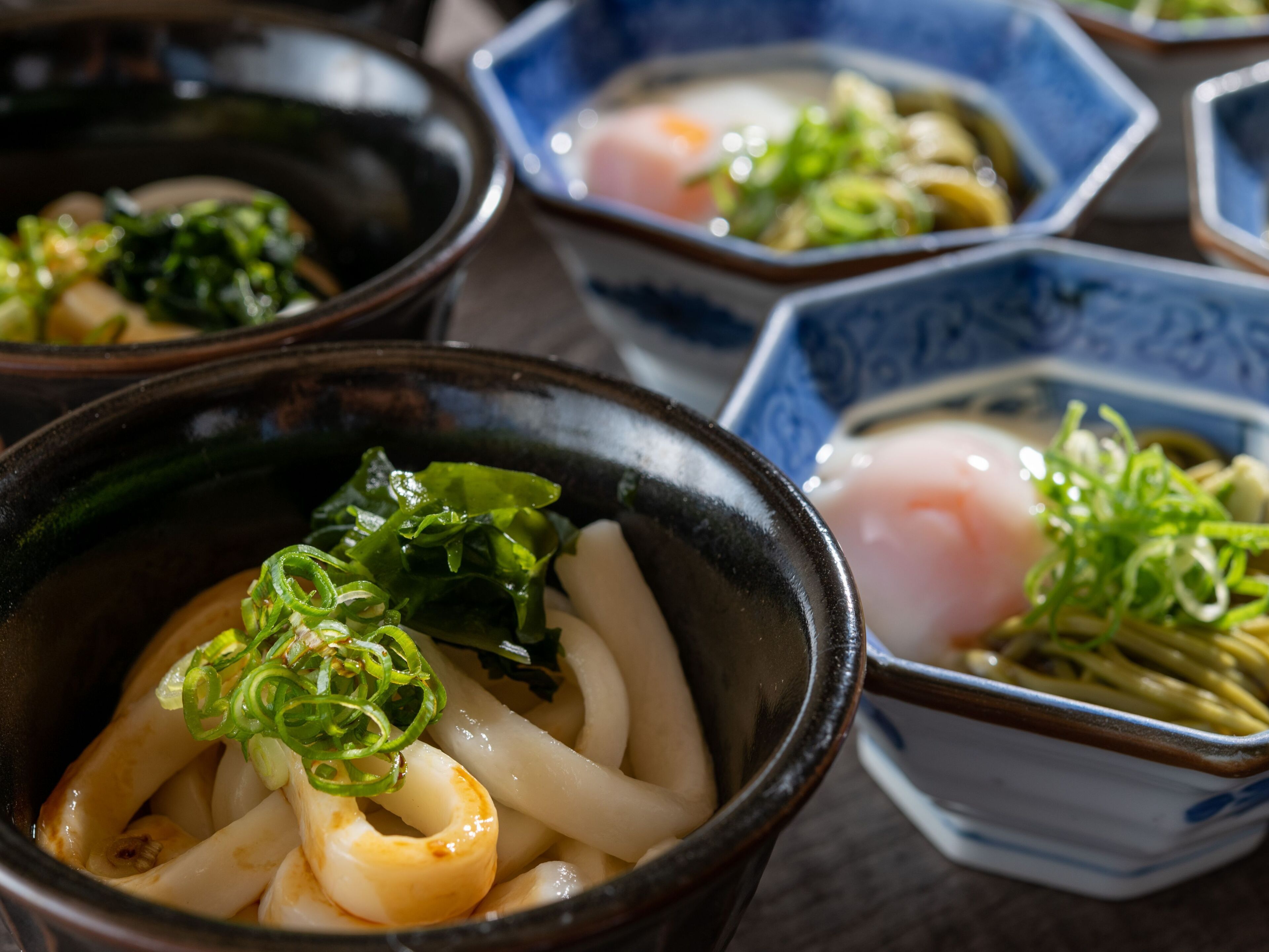 Des bols de ramen garnis de divers accompagnements.