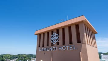 The exterior of Kamenoi Hotel with a clear sky and a view of the surrounding area.