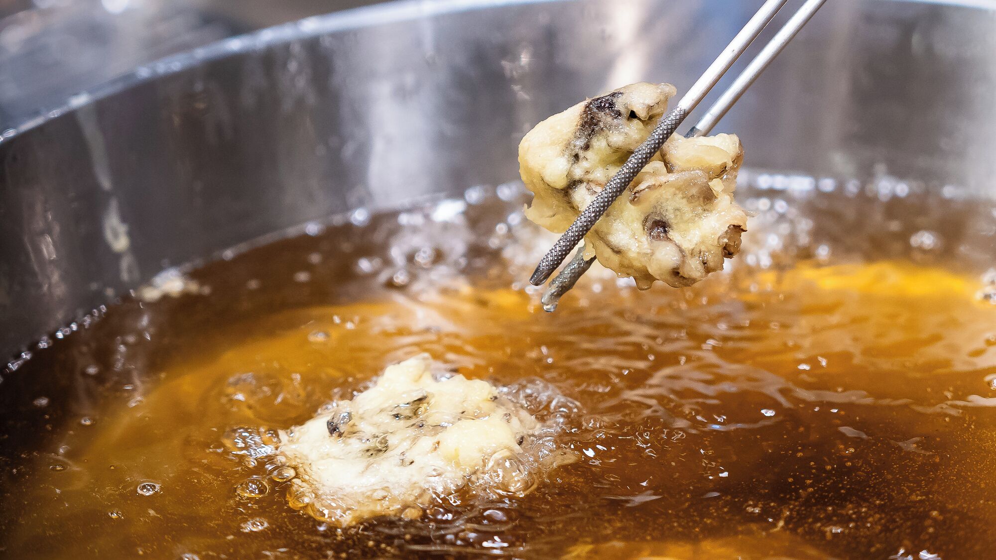 A close-up of a food item being fried in oil.