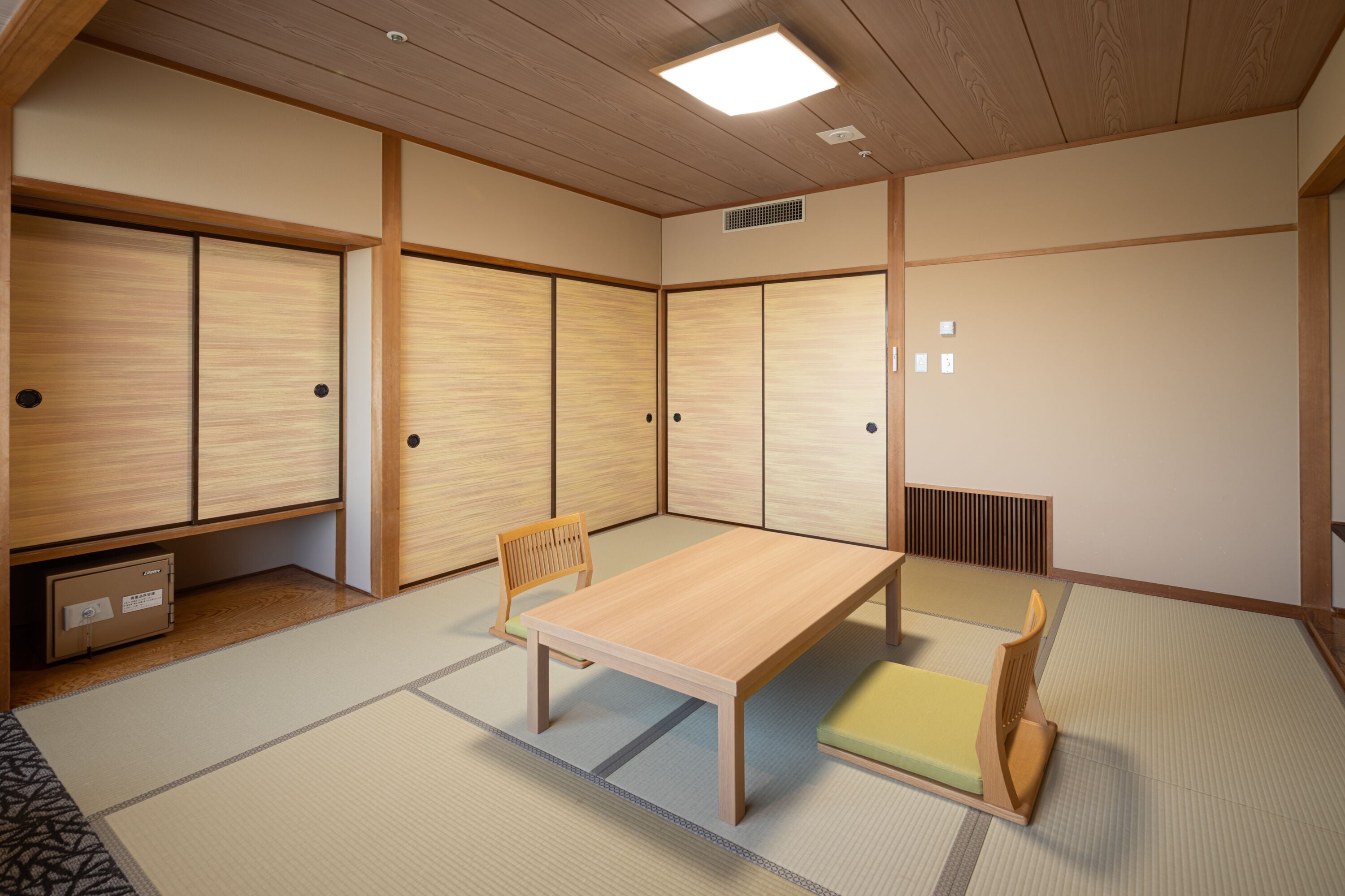 A traditional Japanese room with tatami flooring, a low wooden table, and sliding doors.