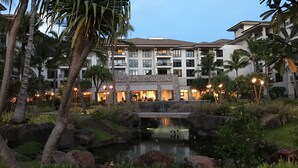 Ein Resort mit Pool, Palmen und einem Gebäude mit mehreren Balkonen.