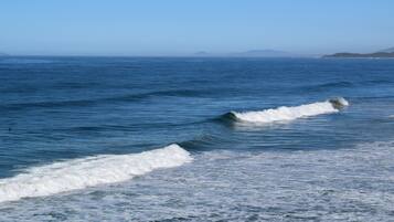 A coastal view with waves and distant landforms.