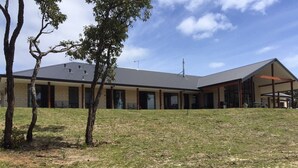 A building with a flat roof, multiple windows, and a covered outdoor area. - Eagle Bay House (Eagle Bay)