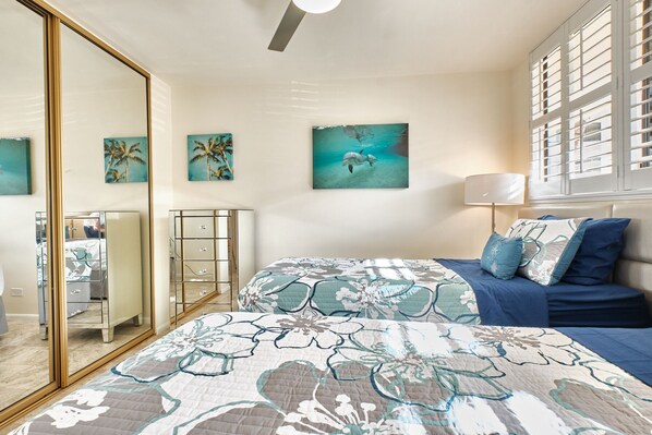 A bedroom with a bed, a dresser, a mirror, and artwork on the walls. - Magnificent....Marvelous....Open Dates...Wonderful Waves! (Village of Ma'alaea)