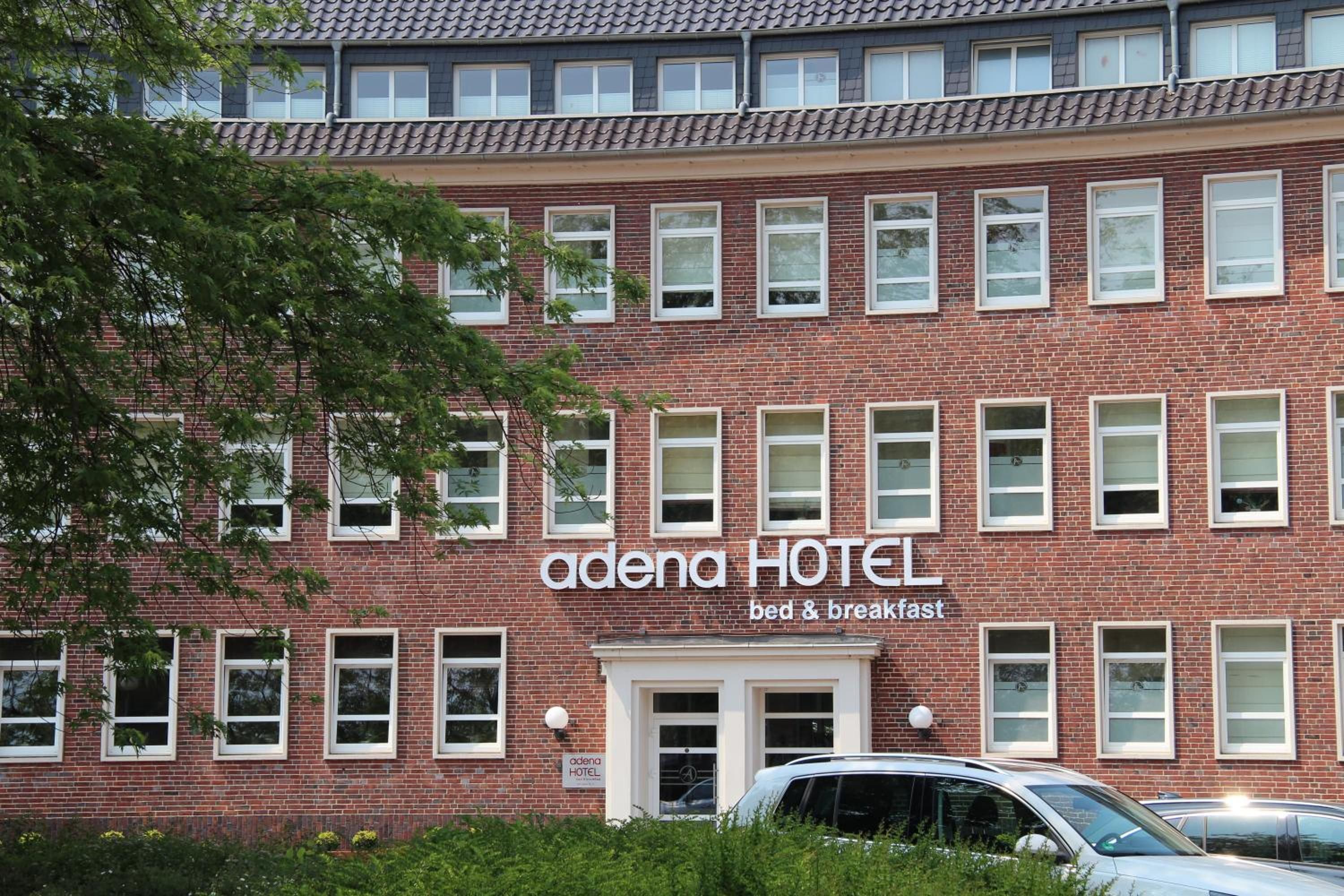 A red brick building with a sign that reads 'odena HOTEL bed & breakfast'.