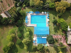 An aerial view of a swimming pool complex surrounded by greenery, with multiple lanes and covered areas. - Kibbutz Beit Alfa Guest House (Gilboa)