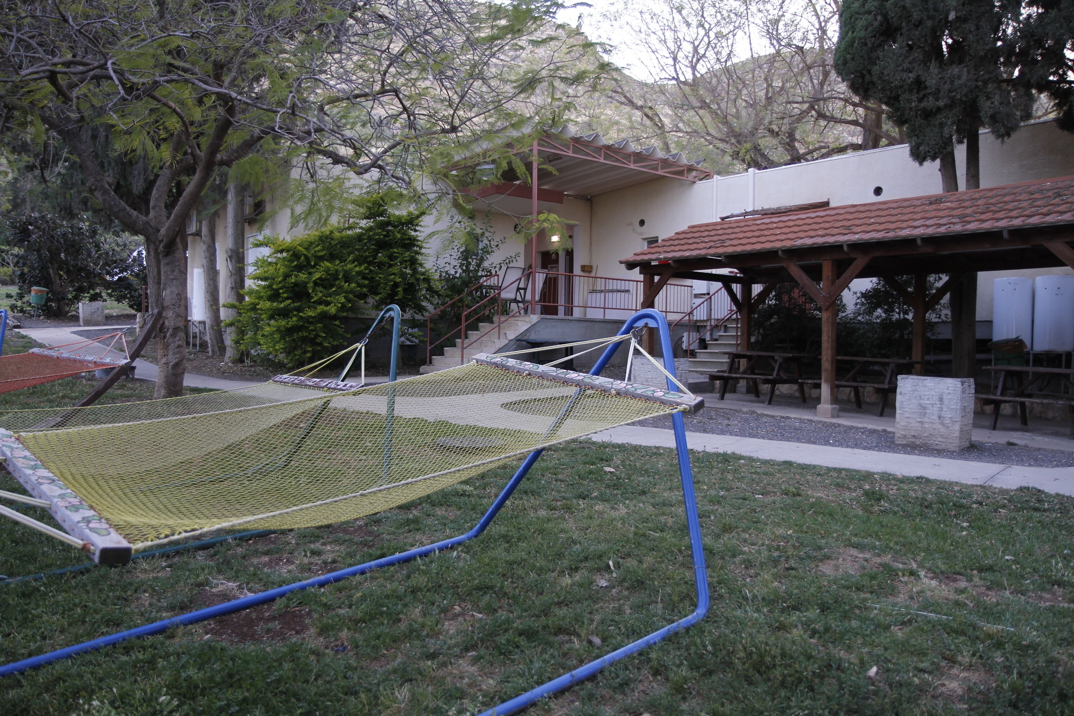 Una hamaca en un área con césped y un edificio al fondo.