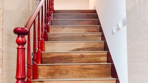 A wooden staircase with red balusters and a handrail, leading to an upper floor. - Jinduohai B&B (Magong)