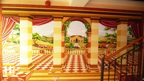 A grand staircase with a checkered floor leading to a balcony with a scenic mural. - Hotel Alla Busa (Noventa Vicentina)