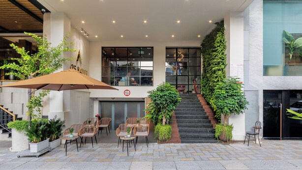 An outdoor seating area with tables and chairs, a staircase, and potted plants. - A25 Premium Hotel - 55 Le Anh Xuan (Ho Chi Minh City)