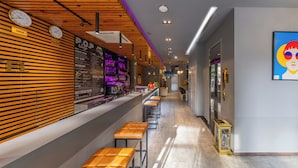 A modern bar area with wooden slats, a long counter, and multiple stools. - A25 Premium Hotel - 55 Le Anh Xuan (Ho Chi Minh City)