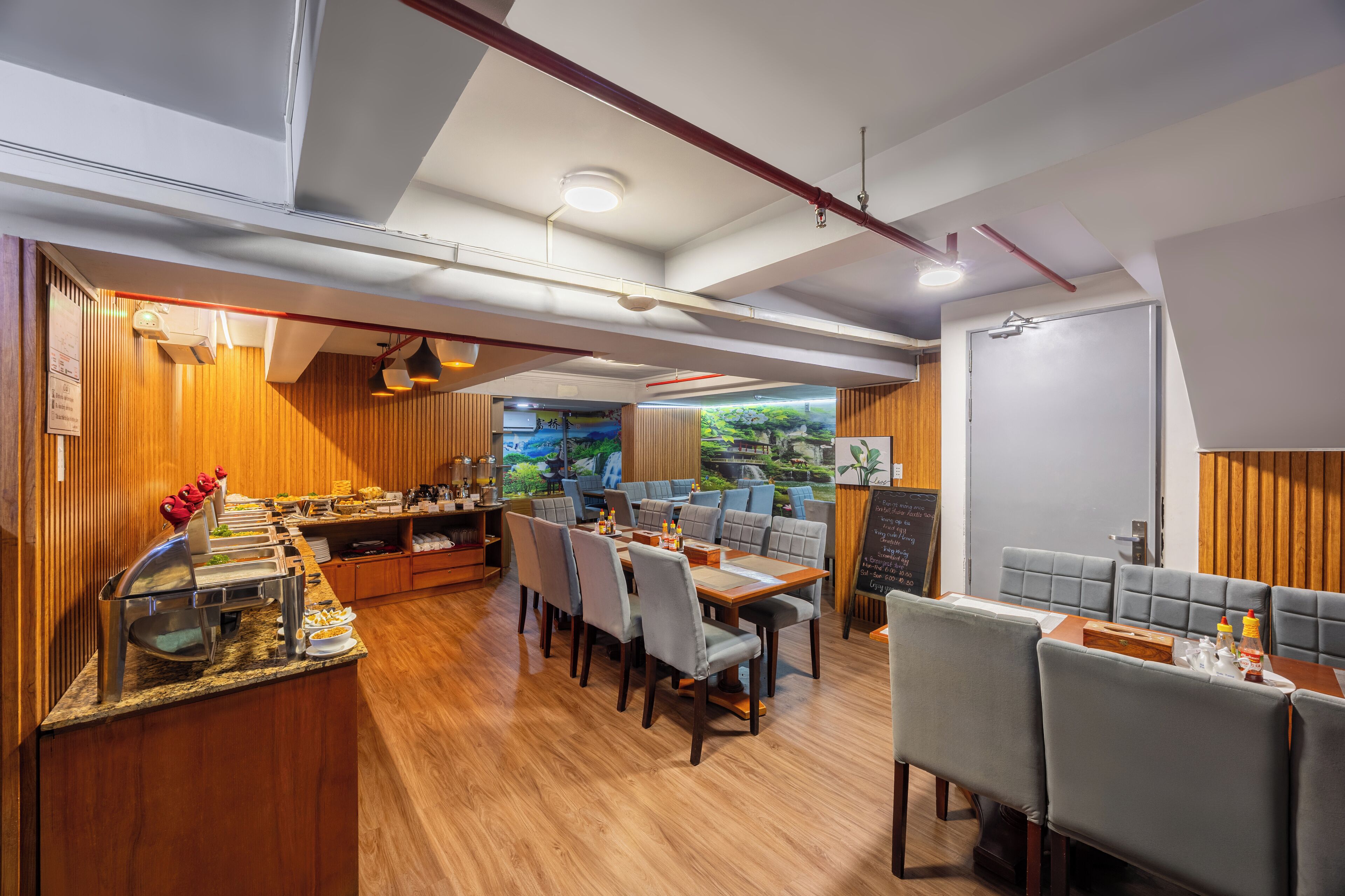 A restaurant with wooden paneling, a buffet area, and several tables and chairs.