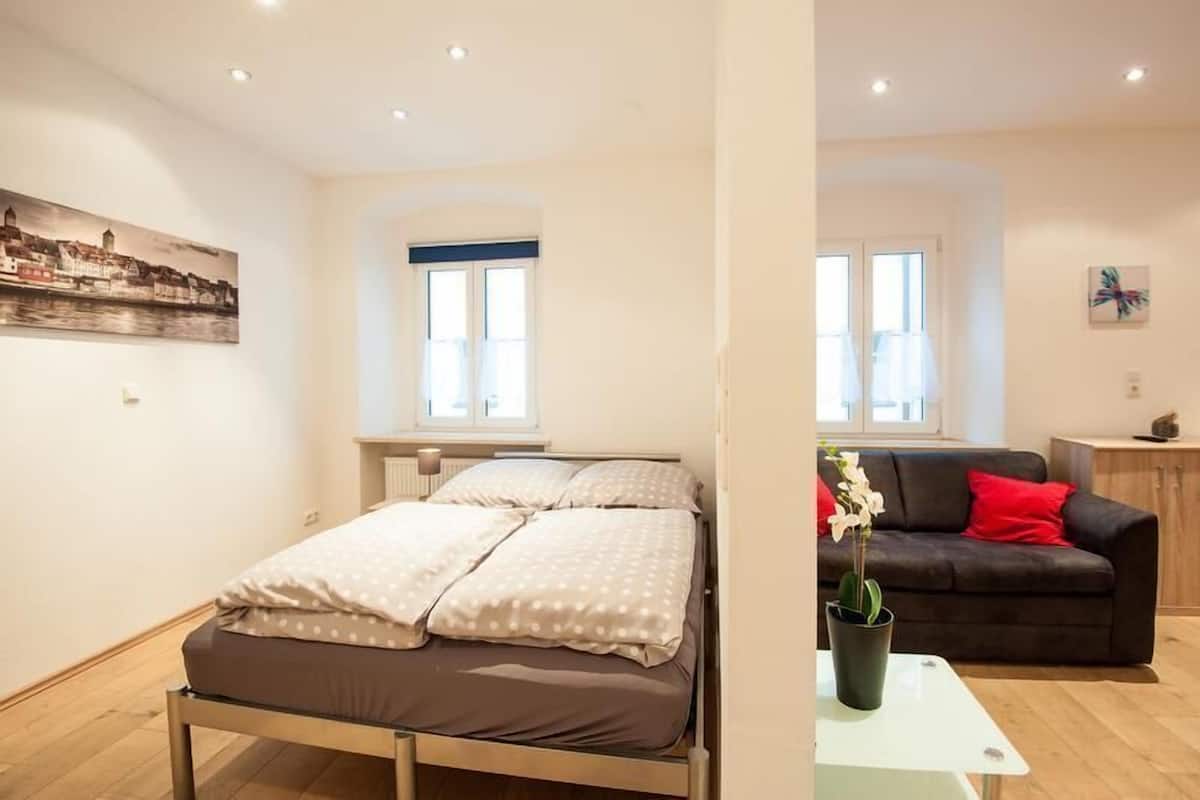 Ein Schlafzimmer mit Bett, Fenster und einem Bild an der Wand.