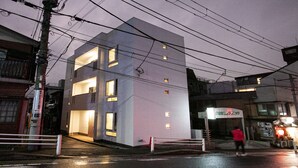 A modern building with multiple windows and a visible entrance.