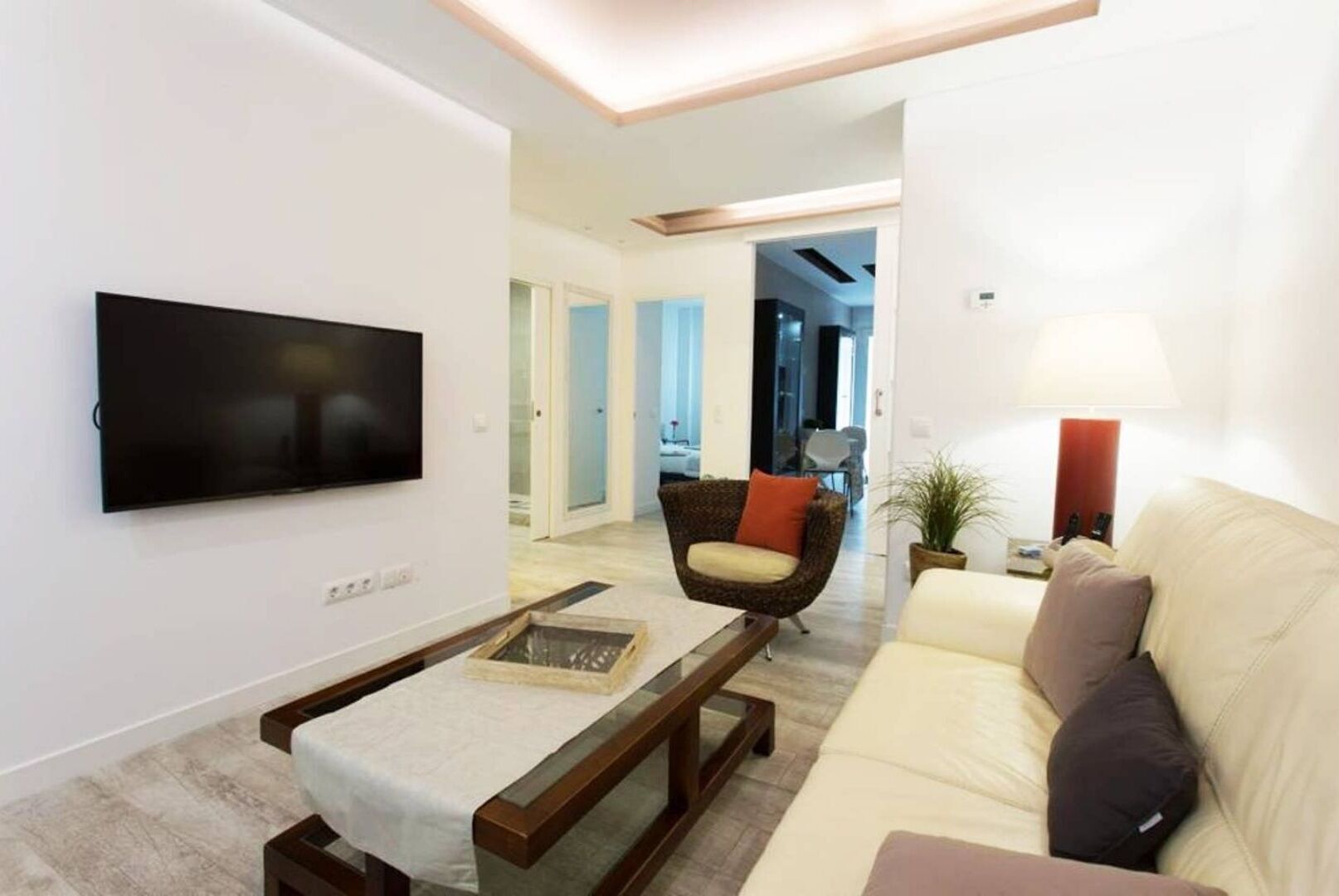 Una sala de estar moderna con una televisión de pantalla plana, un sofá, un sillón y una mesita de centro.
