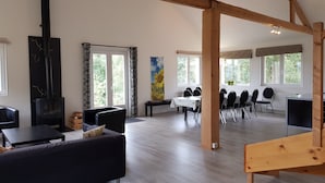 A spacious room with a fireplace, a dining area, and large windows. - Large, light and modern holiday home, beautiful view, beautifully situated (Ban-sur-Meurthe-Clefcy)