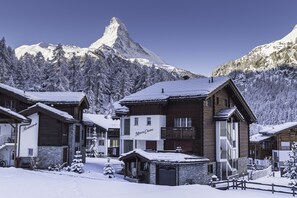 Une station de montagne enneigée, avec des bâtiments en bois, dont un panneau sur lequel on peut lire « Monte Cristo ».