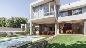 A modern two-story house with a swimming pool, outdoor seating, and a covered patio area. - Houghton Place (Johannesburg)