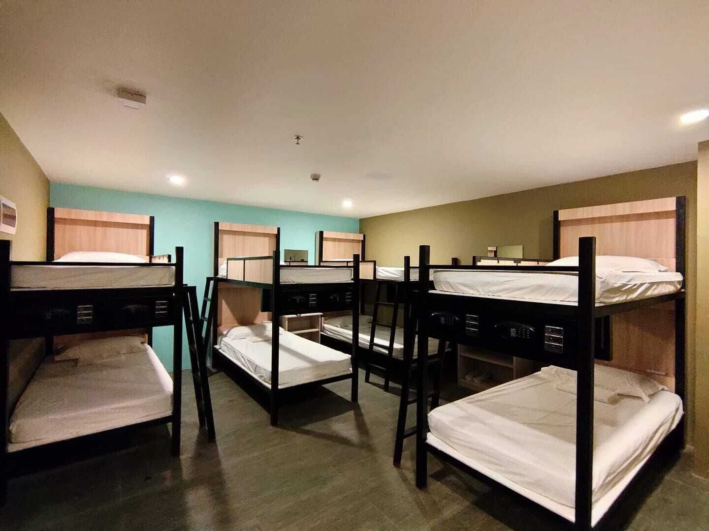 A dormitory room with bunk beds arranged in two rows.
