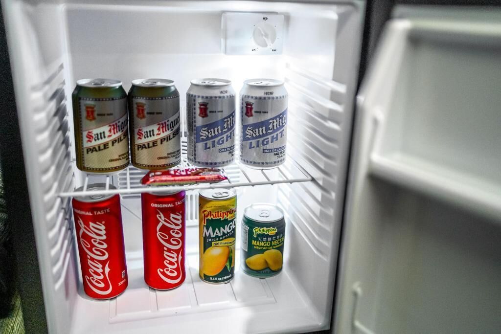Ein Kühlschrank mit sechs Dosen San Miguel Pale Pilsner, zwei Dosen Coca-Cola und zwei Dosen philippinischer Mango-Nektar.