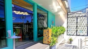 A storefront with a blue awning, glass doors, and a small table with a sign outside. - Felicity Island Hotel (Lapu-Lapu)