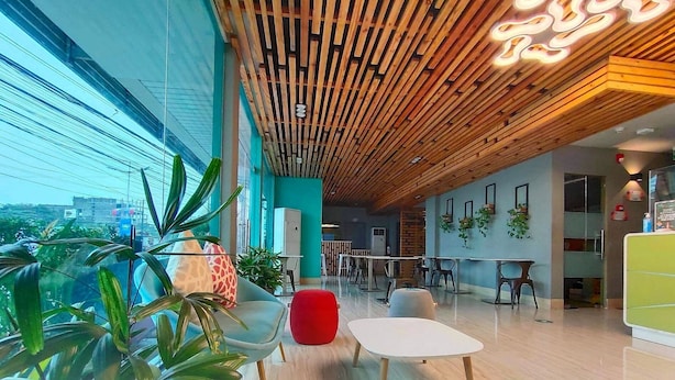 A modern interior with wooden ceiling panels, a glass wall, and indoor plants. - Felicity Island Hotel (Lapu-Lapu)