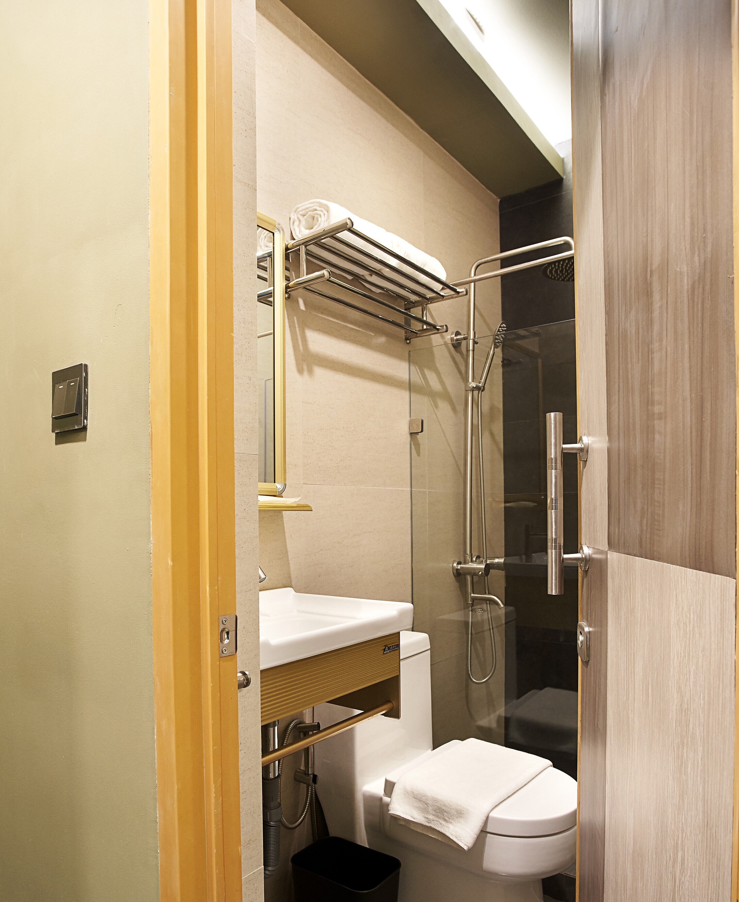 A compact bathroom with a toilet, a sink, and a shower stall.
