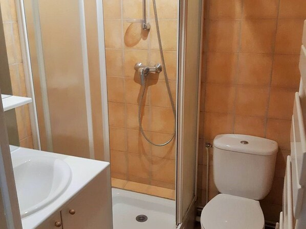 A bathroom with a shower, toilet, and sink.